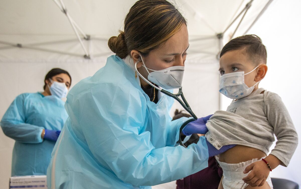Dr. Faraiba Faqeerzada examines 2-year-old Benjamin Salazar at South Central Family Health Center in Los Angeles.