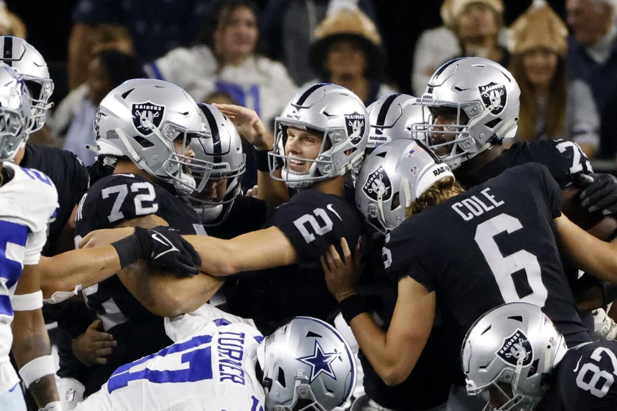 Las Vegas Raiders place kicker Daniel Carlson is congratulated by Jermaine Eluemunor, AJ Cole and others.