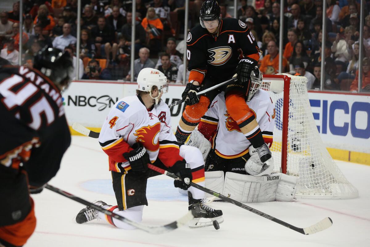 Ducks forward Corey Perry tries to shield Flames goalie Karri Ramo as he deflects a shot from teammate Sami Vatenen during the first period of a Western Conference semifinal game Sunday at Honda Center.