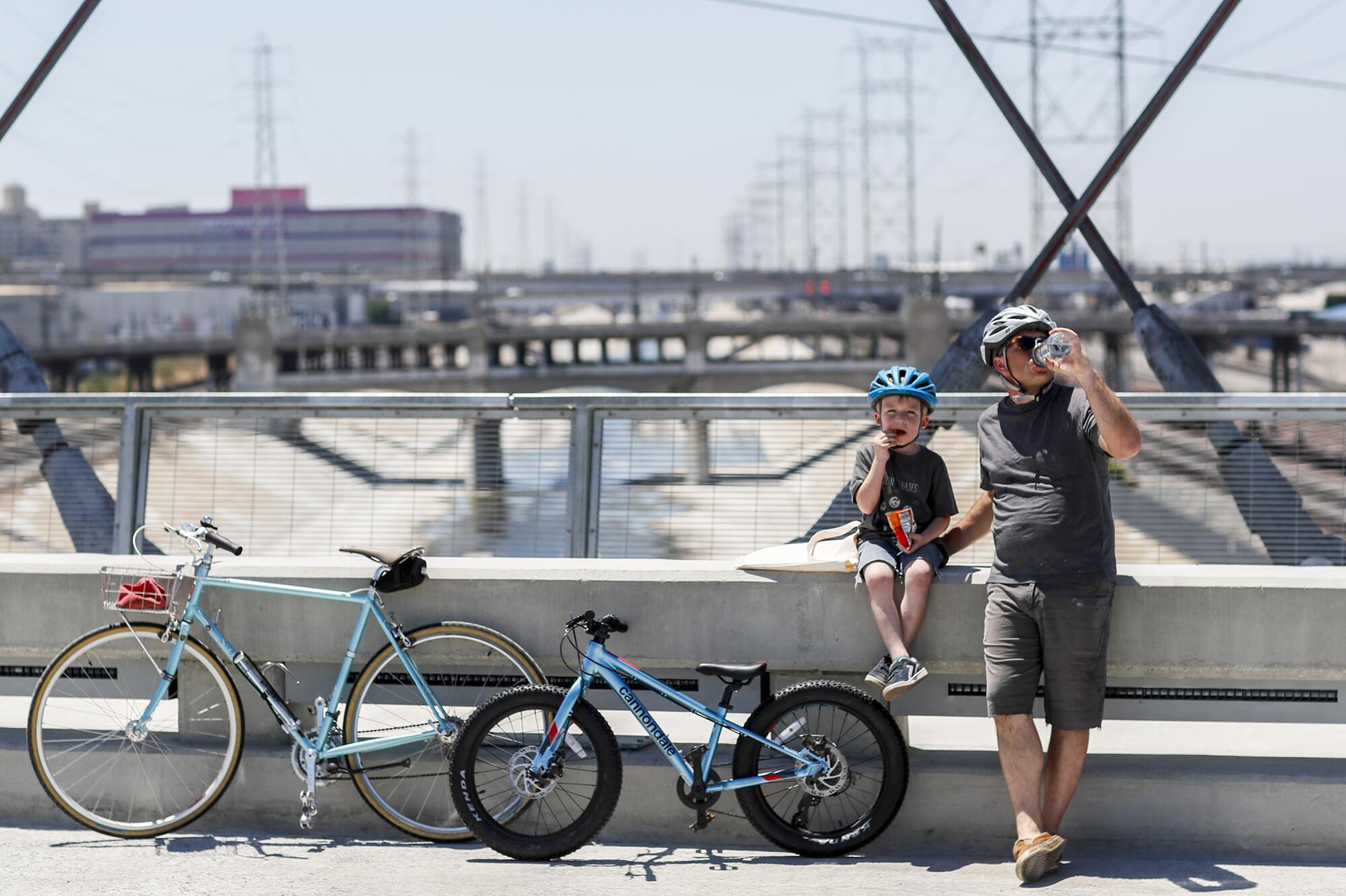 A man and boy stop for a snack while crossing the 6th Street Viaduct.