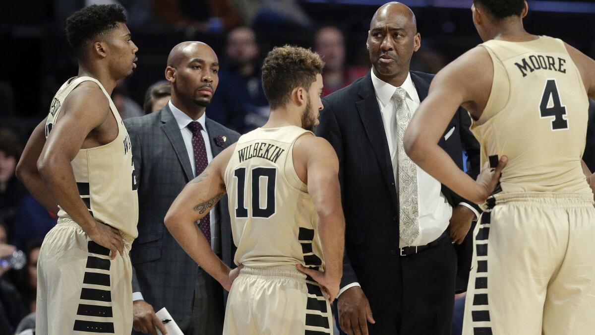 Wake Forest assistant coach Jamill Jones, second from left, with the team and head coach Danny Manning, second from right, during the second half of an NCAA college basketball game.