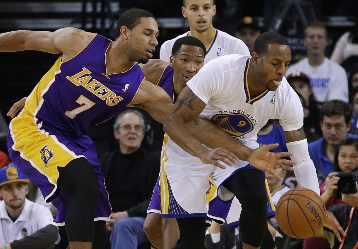 The Lakers' temporary point guard, Xavier Henry, left, tries to steal the ball from Golden State Warriors forward Andre Iguodala during the first half of Saturday's game.