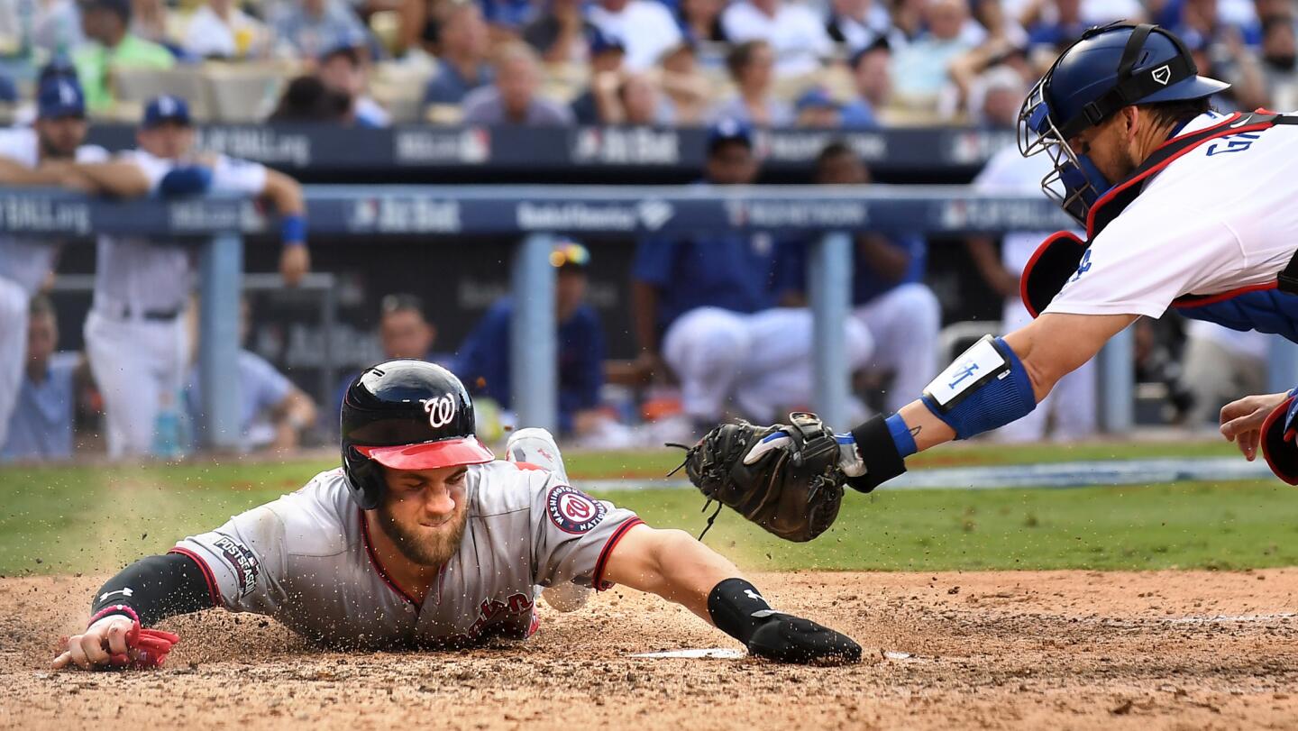 Nationals Bryce Harper beats the tag of Dodgers catcher Yasmani Grandal on a double by Ryan Zimmerman in the 9th inning.