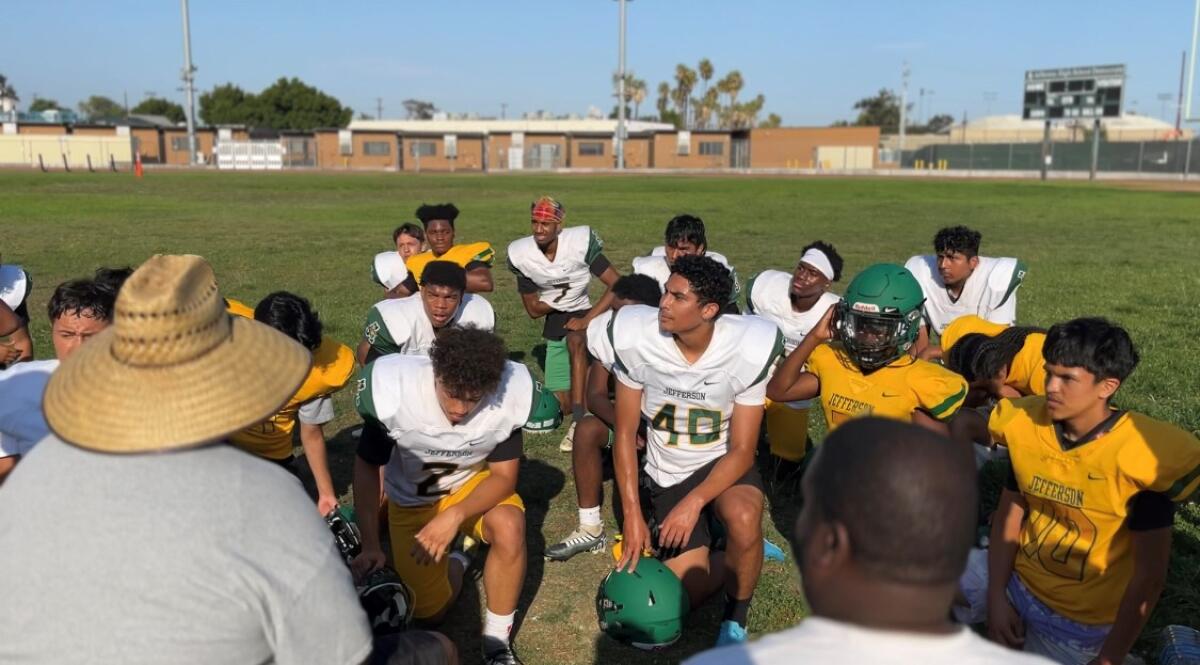 Jefferson High School football kicker Oscar Silva huddles with the team during practice.