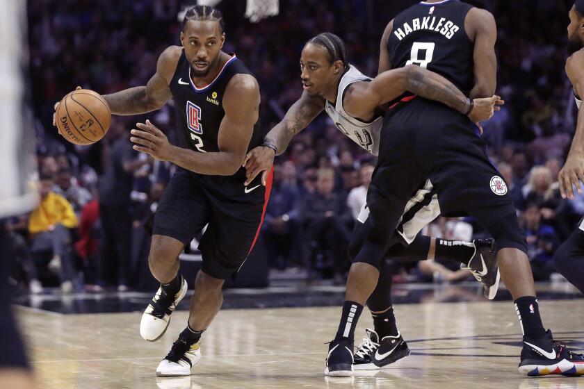 San Antonio Spurs guard DeMar DeRozan, center, battles his way around a pick by Los Angeles Clippers forward Maurice Harkless, right, as forward Kawhi Leonard, left, drives with the ball during the second half of an NBA basketball game in Los Angeles, Thursday, Oct. 31, 2019. (AP Photo/Alex Gallardo)