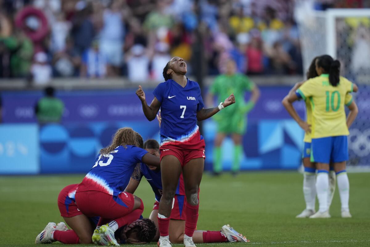 Crystal Dunn of the United States, center, celebrates after defeating Brazil during the women's soccer gold medal match.