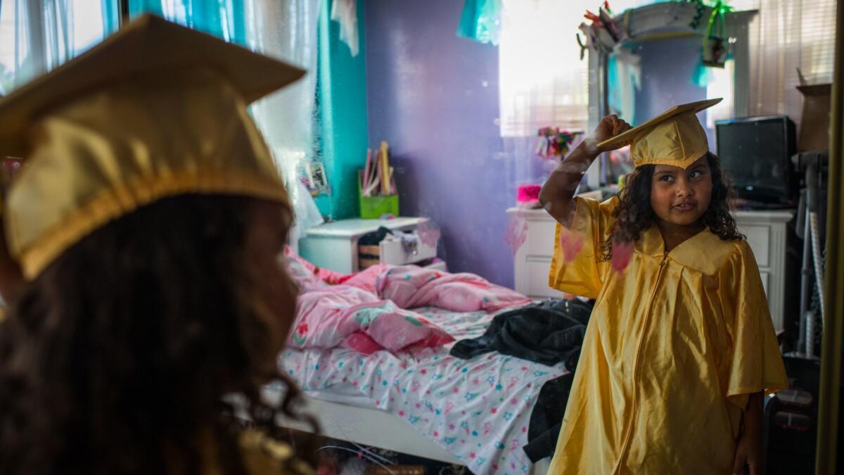 Marley prepares for her kindergarten graduation ceremony at her home in Arleta. (Gabriel S. Scarlett / Los Angeles Times)