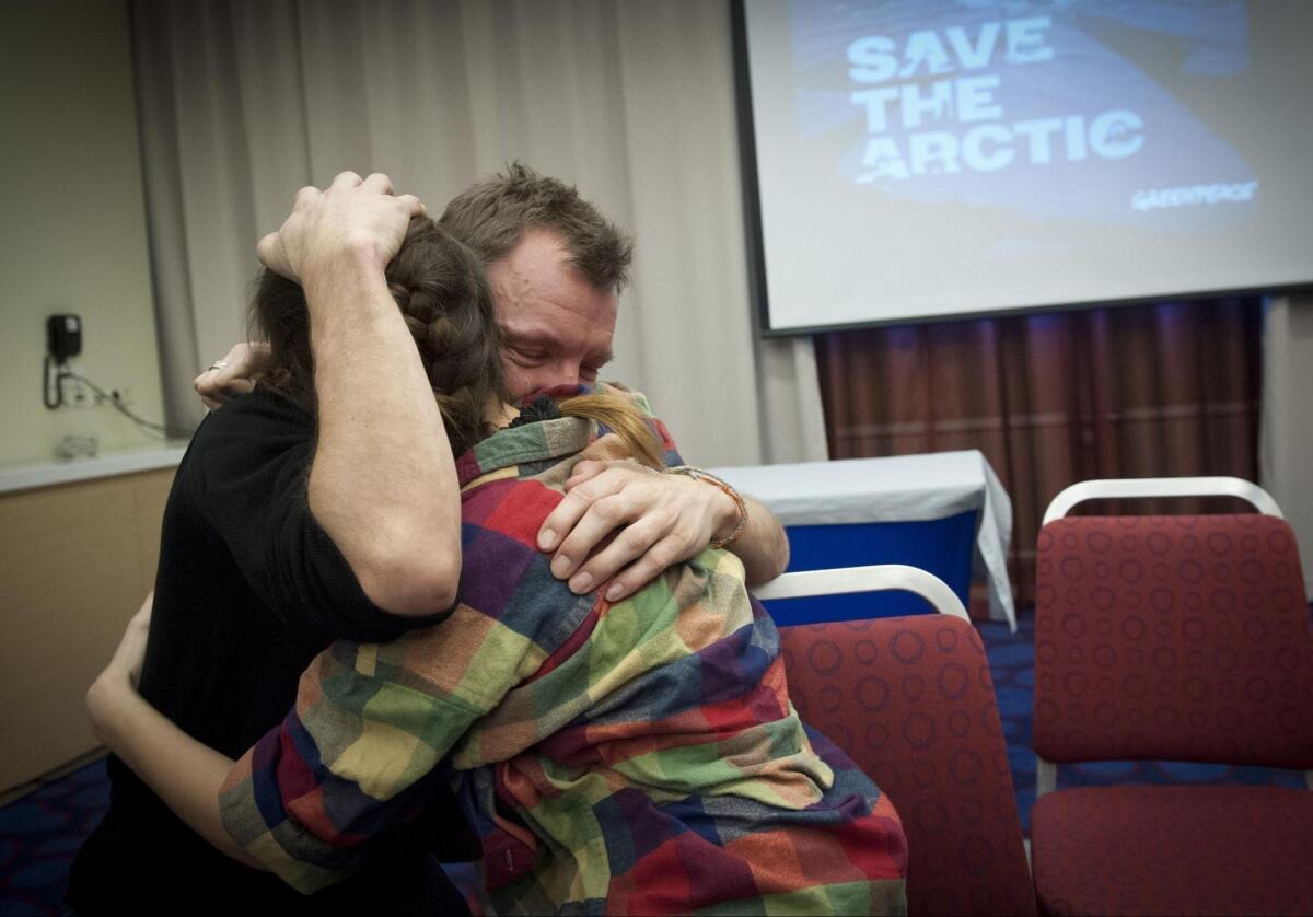Greenpeace activists Philip Ball, from Britain, and Camila Speziale, from Argentina, hug each other after hearing that the Russian parliament passed an amnesty that would likely pardon them.