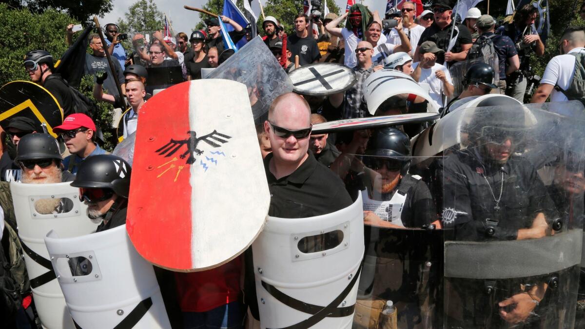 White nationalist demonstrators use shields as they guard the entrance to Lee Park in Charlottesville, Va. on Aug 12. The ACLU is reeling from criticism for defending white supremacists' right to march in Charlottesvile.