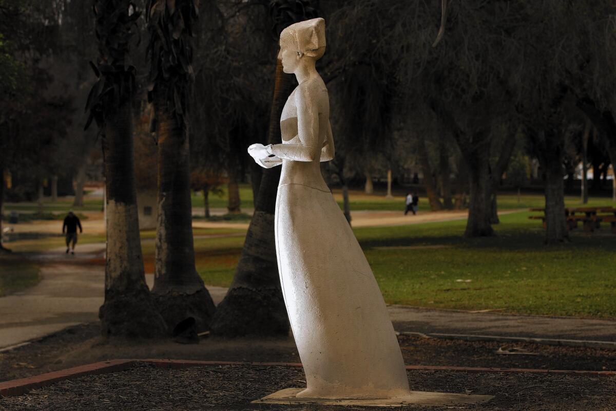 A decaying statue of Florence Nightingale overlooks a lake in Lincoln Park. Recently, someone attached hands to the statue with thin wire in place of the original hands, which have long since disappeared.