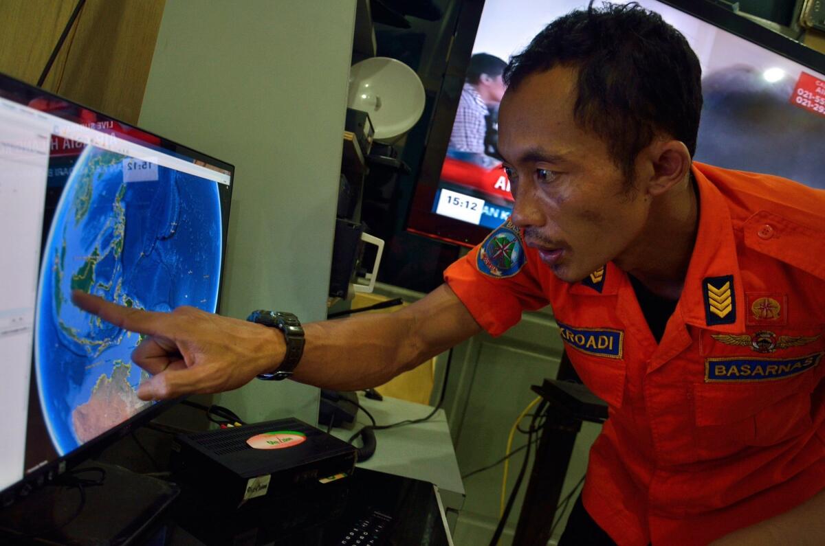 An official from Indonesia's national search and rescue agency in Medan, North Sumatra, points at his computer screen to the spot where Indonesia AirAsia Flight 8501 went missing Dec. 28.
