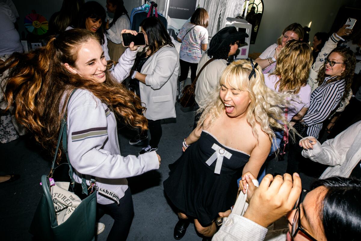 A photo of people dressed in black and white dancing at a Taylor Swift listening party. 