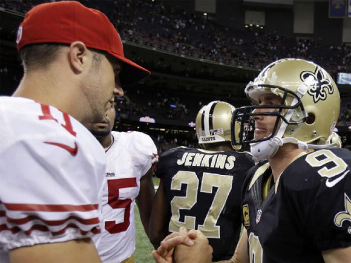 San Francisco's Alex Smith, left, shown shaking hands with New Orleans' Drew Brees, remained on the sidelines during the 49ers' victory over the Saints on Sunday.