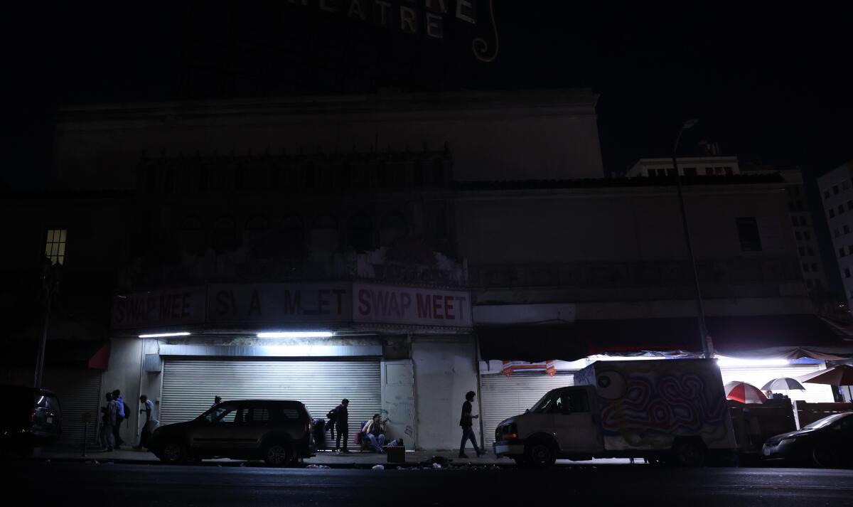 People walk by Westlake Theater near MacArthur Park on Tuesday, 