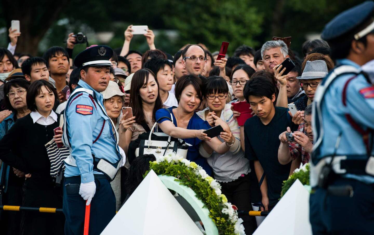 People try to get a glimpse of the wreath laid by President Obama at Hiroshima Peace Memorial Park.
