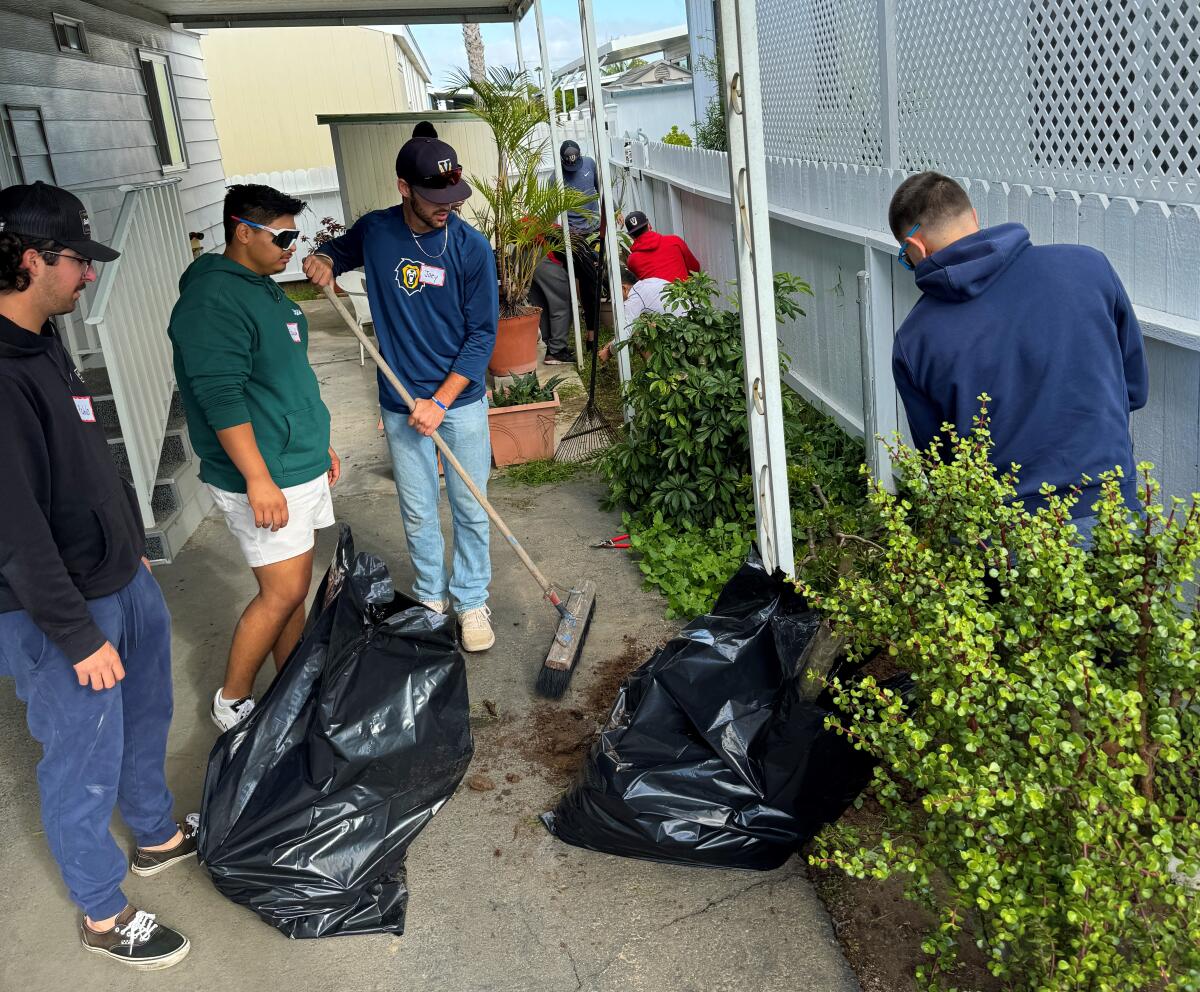 Vanguard University students Saturday help clear the yard of a mobile home as part of a Love Costa Mesa neighboring day.