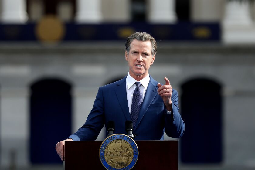 Gov. Gavin Newsom talks, gesturing with his left hand, as he gives the inaugural address after taking the oath of office 