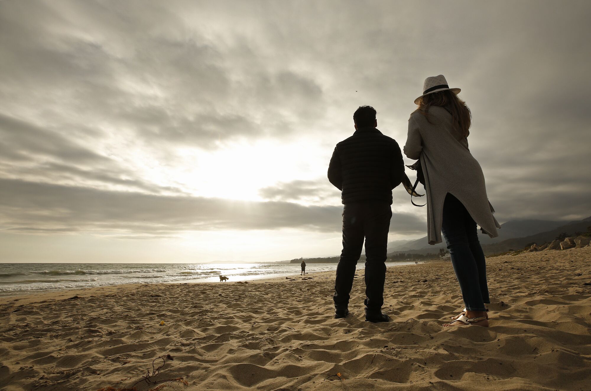 Photographer Carlos Gauna stands with his wife, Andressa, on a beach. 