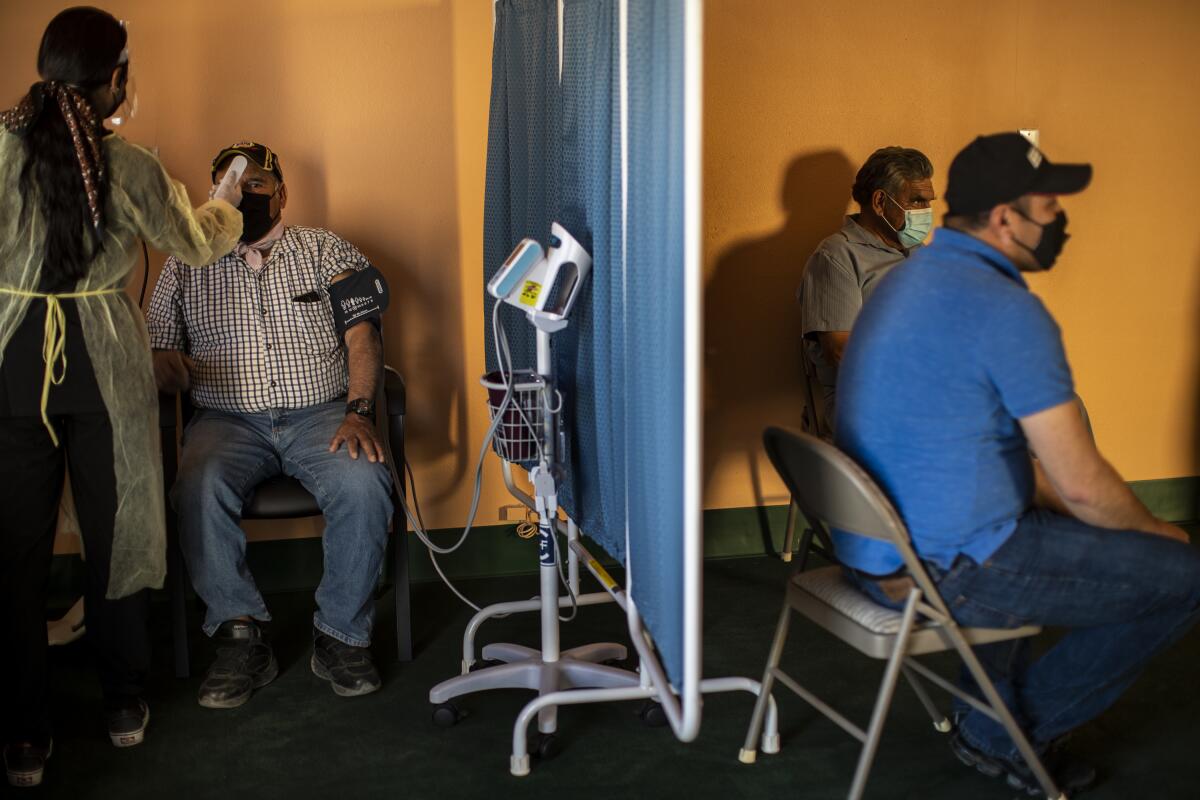 A man gets his temperature taken before getting the COVID-19 vaccine