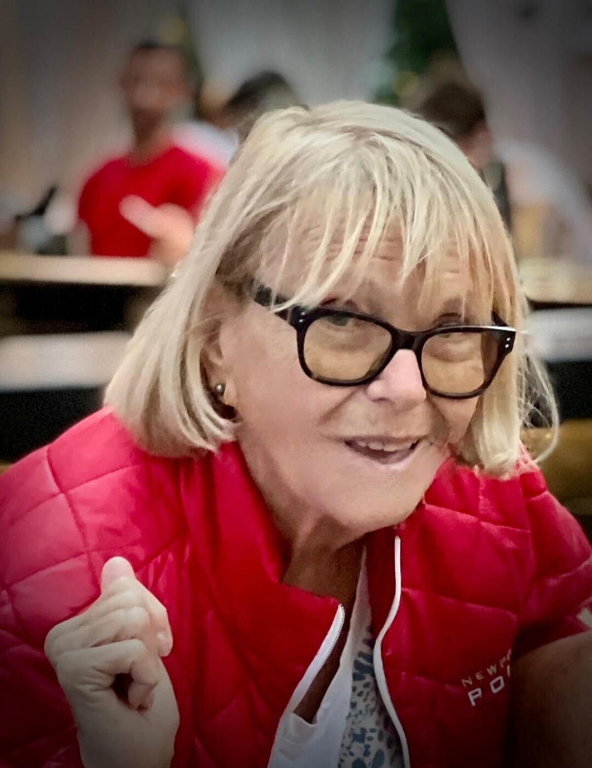 Genevieve Lane wearing glasses and a red jacket.