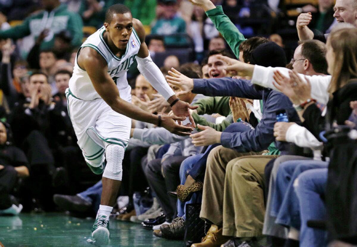 Celtics point guard Rajon Rondo receives congratulations from fans courtside in Boston after scoring against the Charlotte Bobcats during a game earlier this month.