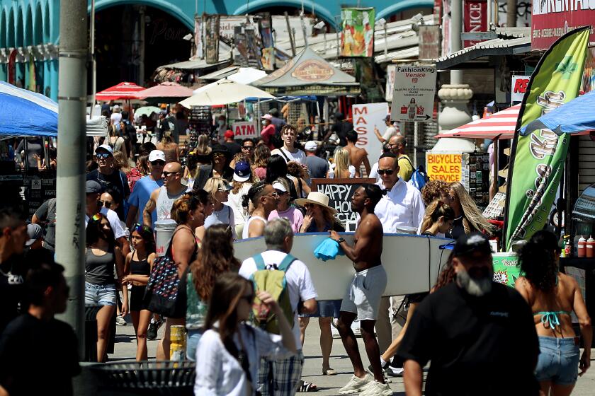 VENICE BEACH, CALIF. - AUG. 27, 2022. Beachgoers crowd the Venice Beach boardwalk, where the weather was mild in comparison to inland. areas on Saturday, Aug. 27, 2022. A general cooling trend lasts until mid-week when hotter summer weather is expected to return. (Luis Sinco / Los Angeles Times)