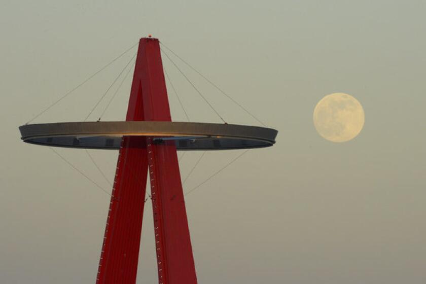 The moon rises next the Los Angeles Angels' "Big A" sign during their baseball game against the Pittsburgh Pirates.