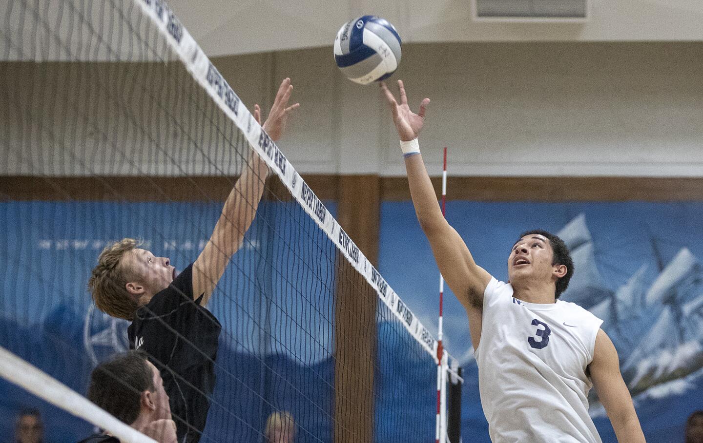Newport Harbor's Koe Karlous goes up for a ball on the net against a La Jolla defender during a CIF Southern California Regional Division I playoff game on Tuesday, May 22.