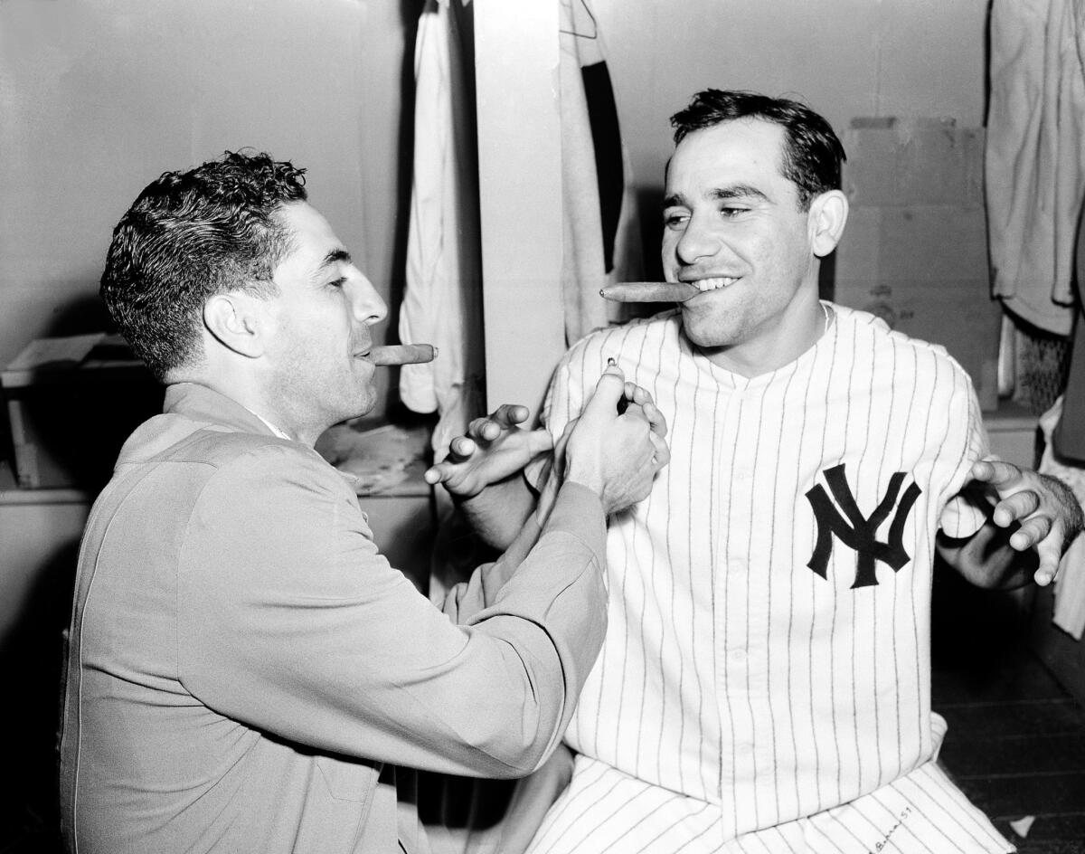 Yankees shortstop Phil Rizzuto, left, celebrates with teammate Yogi Berra after the birth of the catcher's son.