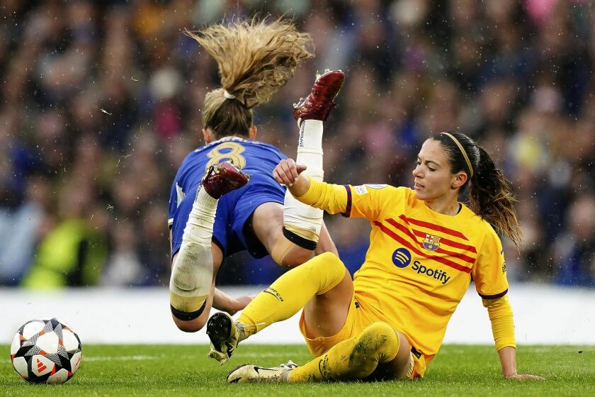 Chelsea's Melanie Leupolz, left, and Barcelona's Aitana, right, challenge for the ball during the Women's Champions League, semi final second leg, soccer match between FC Chelsea and FC Barcelona in London, England, Saturday, April 27, 2024. (Zac Goodwin/PA via AP)