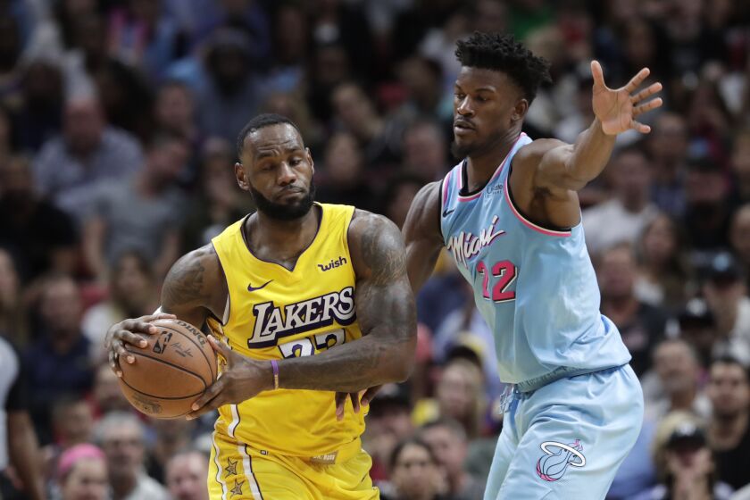 Miami Heat forward Jimmy Butler (22) defends Los Angeles Lakers forward LeBron James during the second half of an NBA basketball game, Friday, Dec. 13, 2019, in Miami. The Lakers won 113-110. (AP Photo/Lynne Sladky)