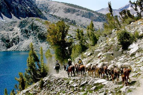 Line of riders travel a remote trail