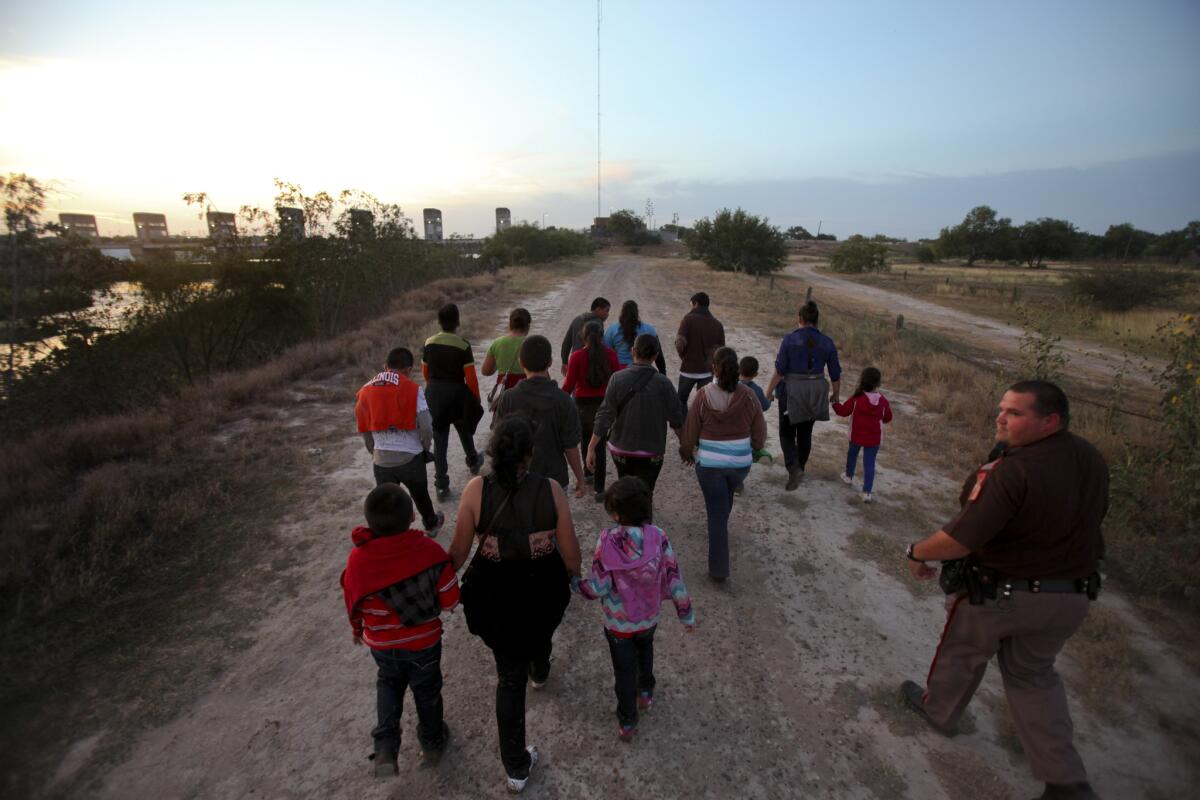 A Hidalgo County, Texas, deputy, right, guides a group of Guatemalan immigrants who crossed the border into the United States in 2014.