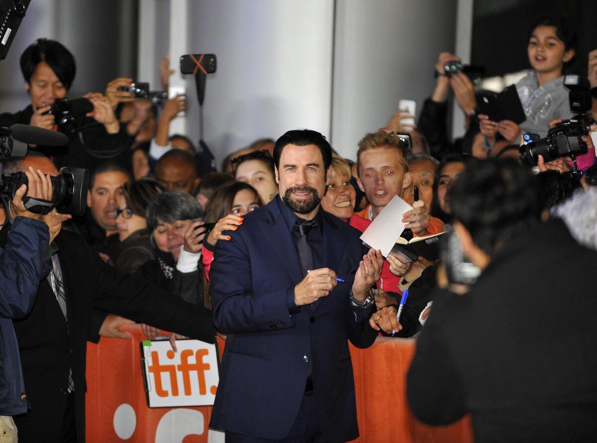 Actor and cast member John Travolta interacts with the fans before the screening of "The Forger" at the 39th annual Toronto International Film Festival.