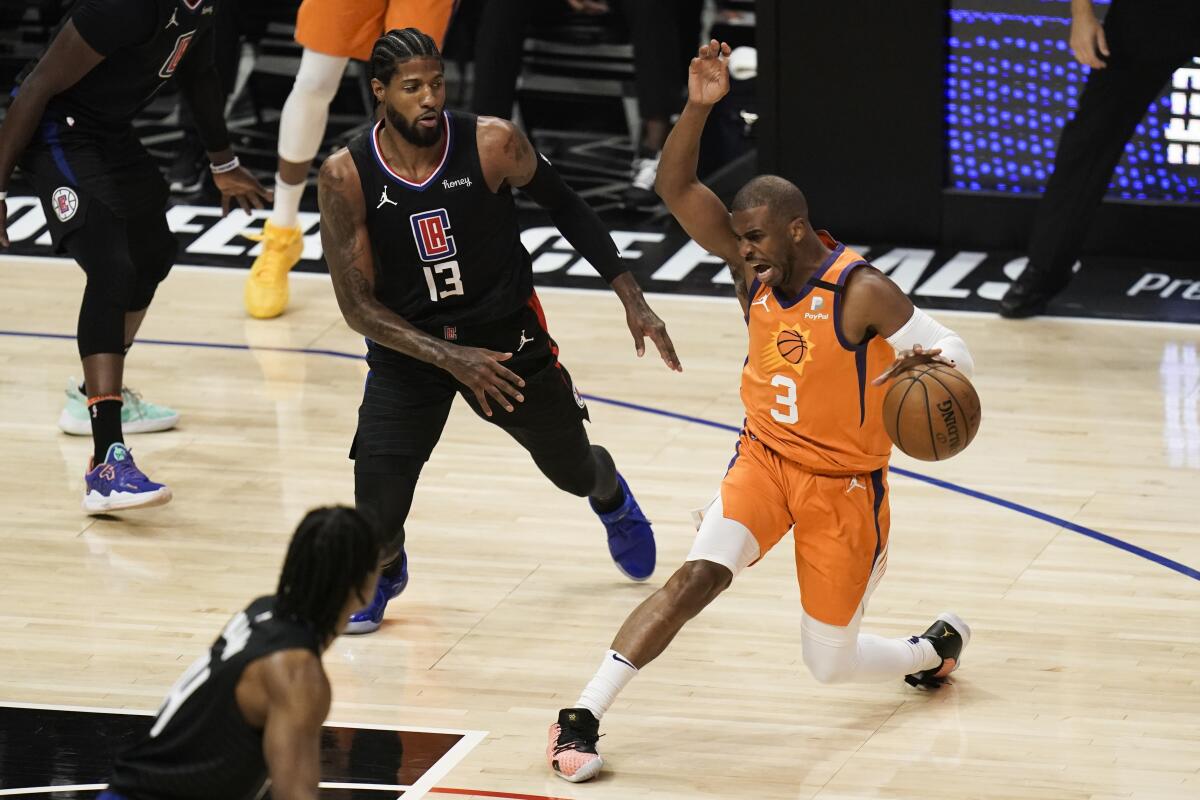 Suns guard Chris Paul drives against Clippers forward Paul George.
