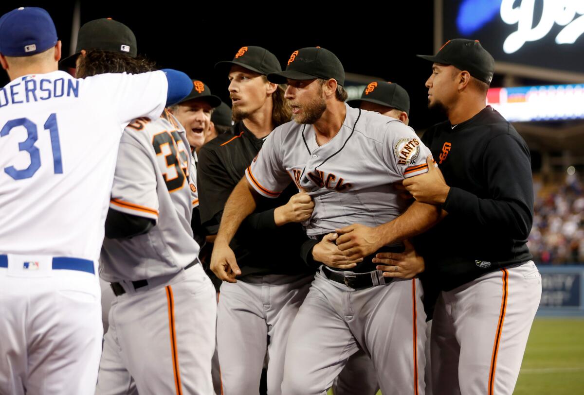 Benches clear when an argument breaks out involving Giants starting pitcher Madison Bumgarner (40), being held at right, and Dodgers right fielder Yasiel Puig (not pictured) in the seventh inning.