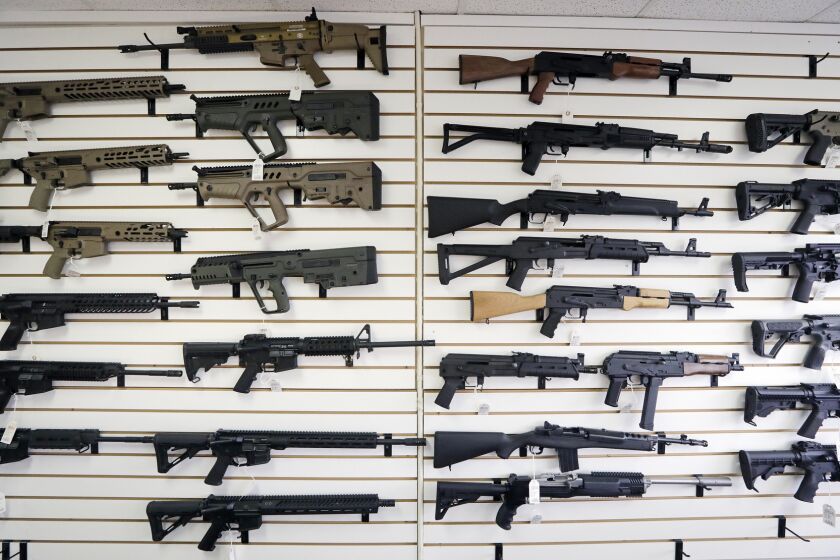 FILE - In this Oct. 2, 2018, file photo, semi-automatic rifles fill a wall at a gun shop in Lynnwood, Wash. Mass shootings in Georgia and Colorado in March 2021, that left several people dead, have reignited calls from gun control advocates for tighter restrictions on buying firearms and ammunition. But with Democrats in control of the federal government, gun rights advocates have been persuading Republican-run state legislatures to go the other way, making it easier to obtain and carry guns.(AP Photo/Elaine Thompson, File)