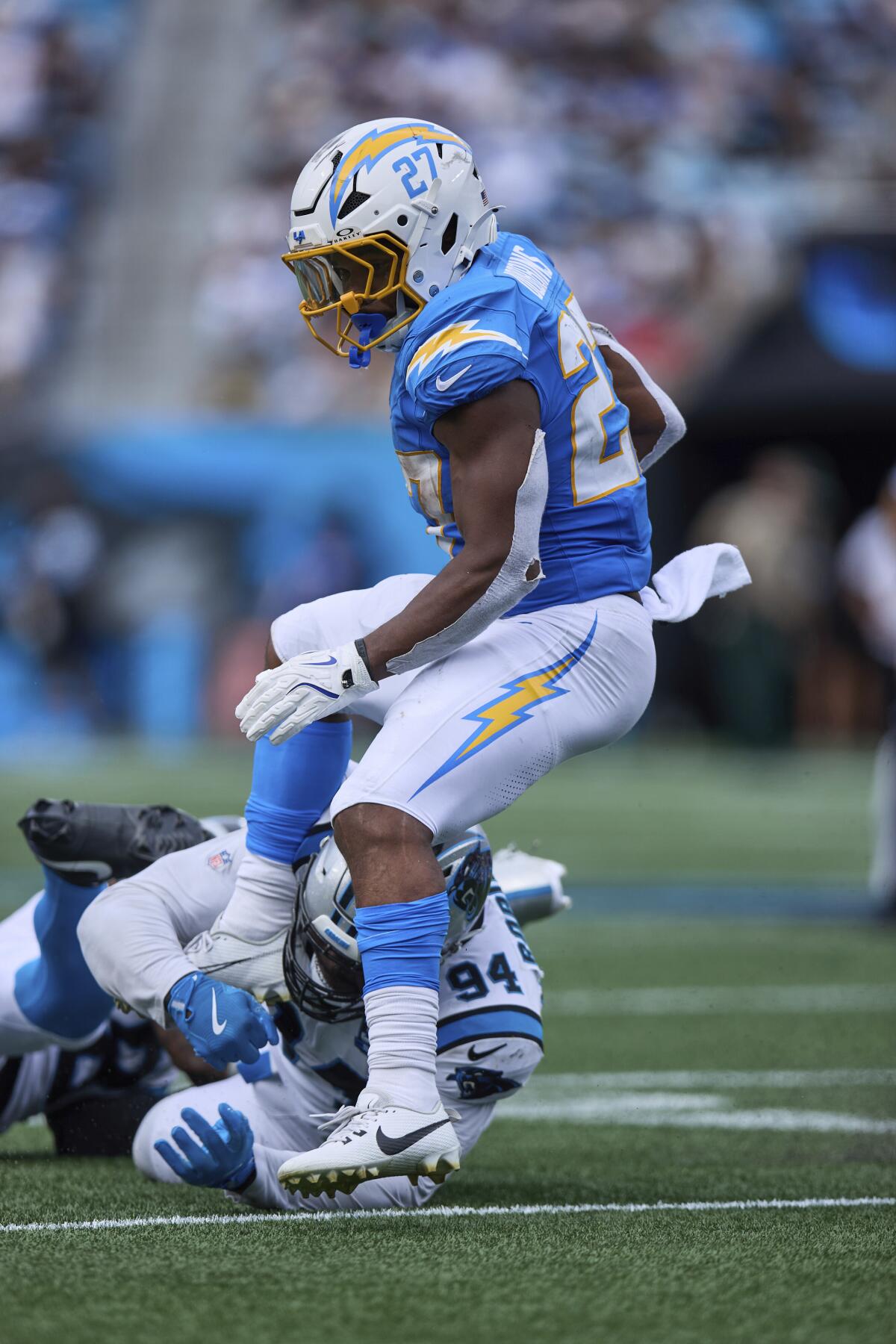 Chargers running back J.K. Dobbins (27) is tripped up by  Panthers defensive end A'Shawn Robinson (94).