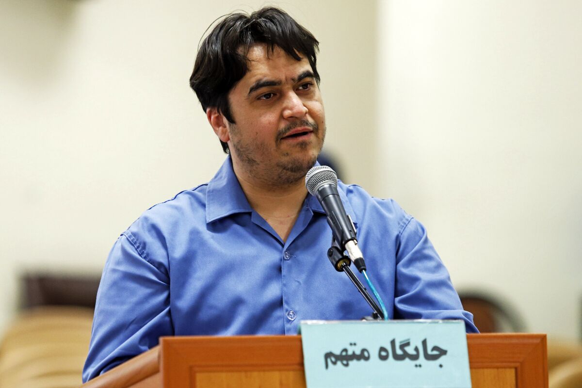 Journalist Ruhollah Zam speaks at his trial at a lectern.