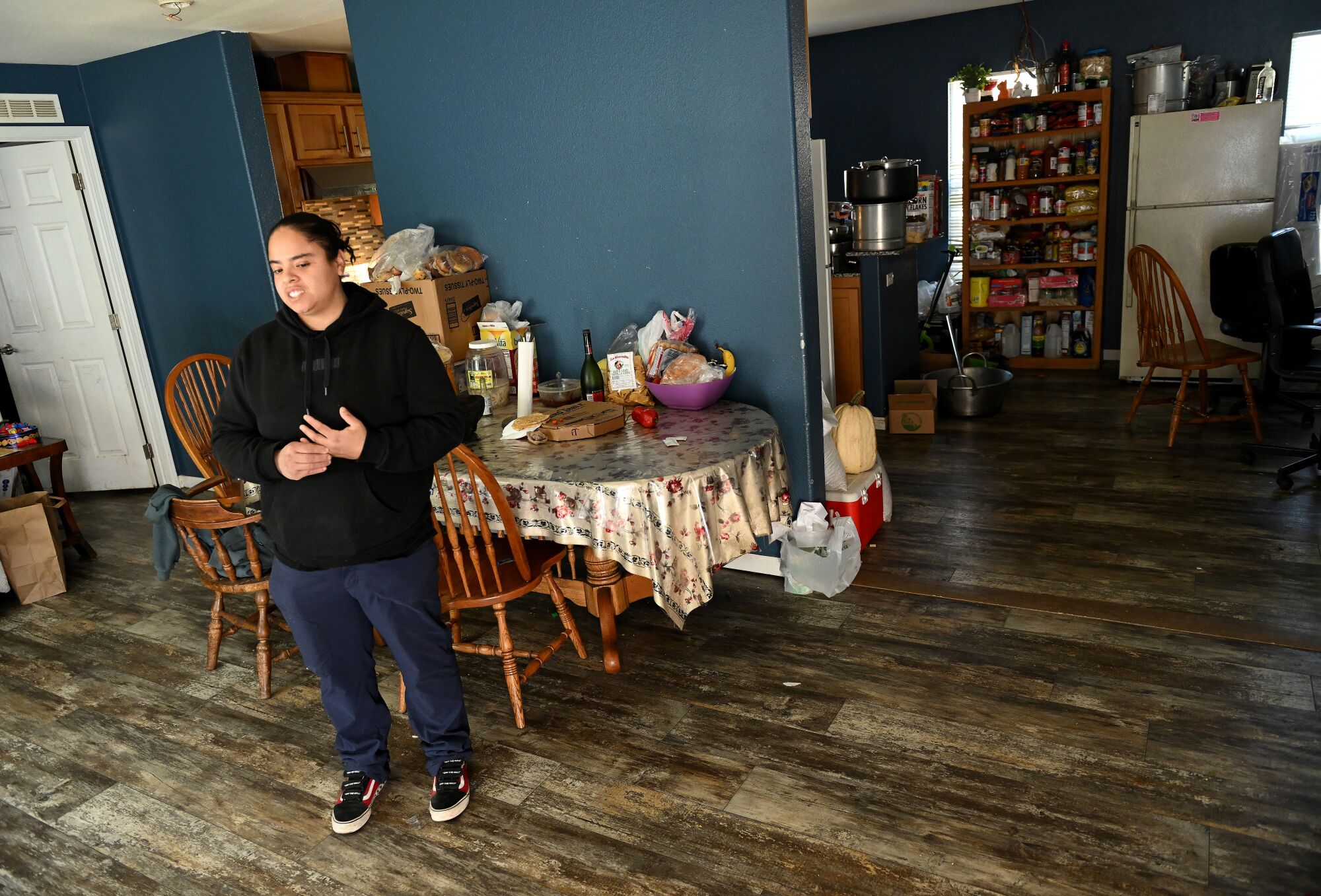 A woman stands by a small dining table