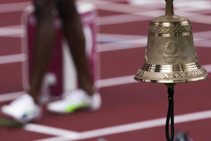 The bell hangs near the finish line at the Tokyo Olympic Stadium.