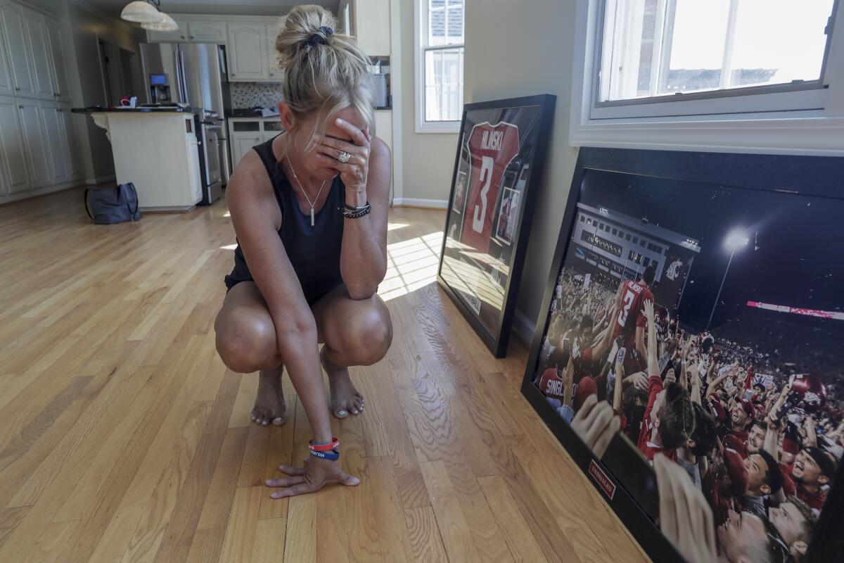 Kym Hilinski pauses as she looks at a photo of her son, Tyler, after he led Washington State to a comeback victory over Boise State in 2017.