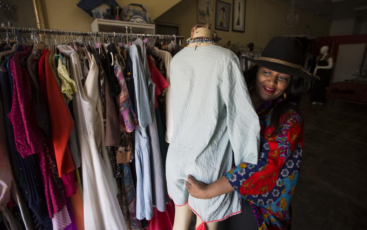 Zoe Guillory moves a mannequin in her vintage shop, Zoe's Vintique, on West Adams Boulevard in Los Angeles.