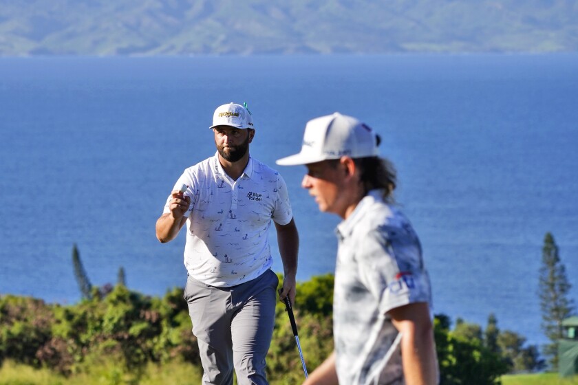 Jon Rahm, of Spain, left, and Cameron Smith walks off the 14th green during the third round of the Tournament of Champions golf event, Saturday, Jan. 8, 2022, at Kapalua Plantation Course in Kapalua, Hawaii. (AP Photo/Matt York)