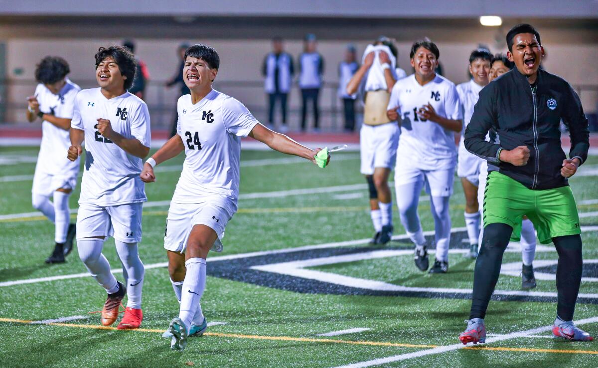 Eduardo Villegas (24) leads a celebration of Contreras High soccer players after clinching their first league title.