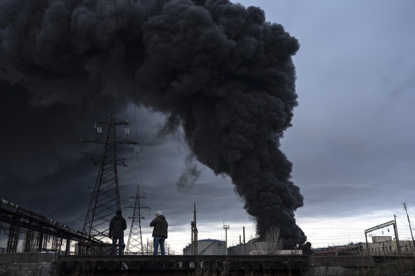 People watch as smoke rises in the air after shelling in Odesa, Ukraine, Sunday, April 3, 2022. (AP Photo/Petros Giannakouris)
