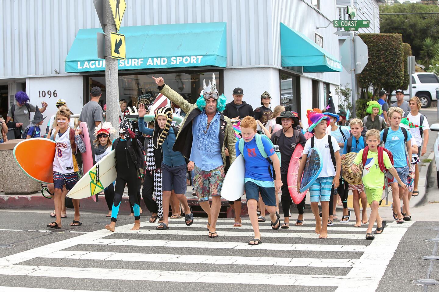 Young surfers, or "groms," march toward Thalia Street Beach on Friday in the Laguna Beach Surf School's costume parade.