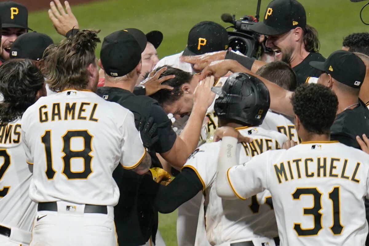 Pittsburgh Pirates' Bryan Reynolds, center, is surrounded by teammates at home plate as he celebrates a game-ending home run against the Milwaukee Brewers in the ninth inning of a baseball game Wednesday, Aug. 3, 2022, in Pittsburgh. The Pirates won 8-7. (AP Photo/Keith Srakocic)