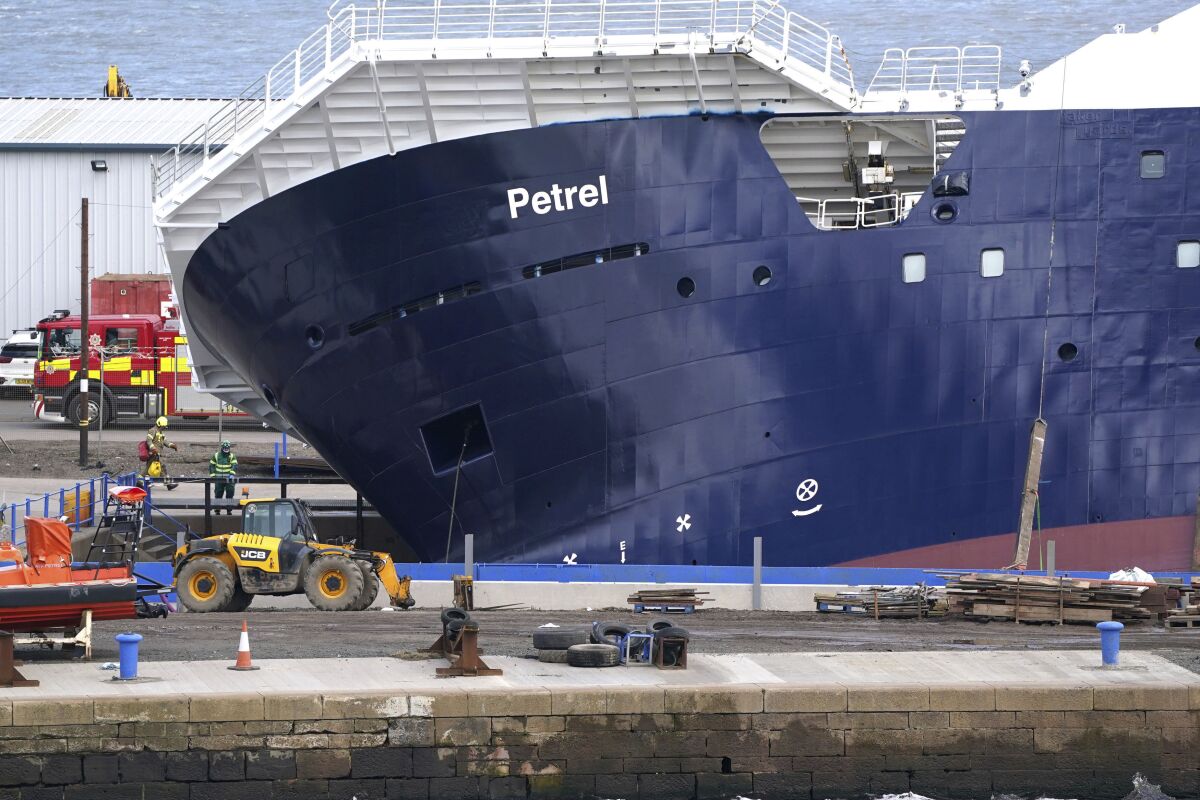 Emergency services work at Imperial Dock, where a ship has become dislodged from its holding and is partially toppled over, in Leith, Edinburgh, Scotland, Wednesday March 22, 2023. (Andrew Milligan/PA via AP)