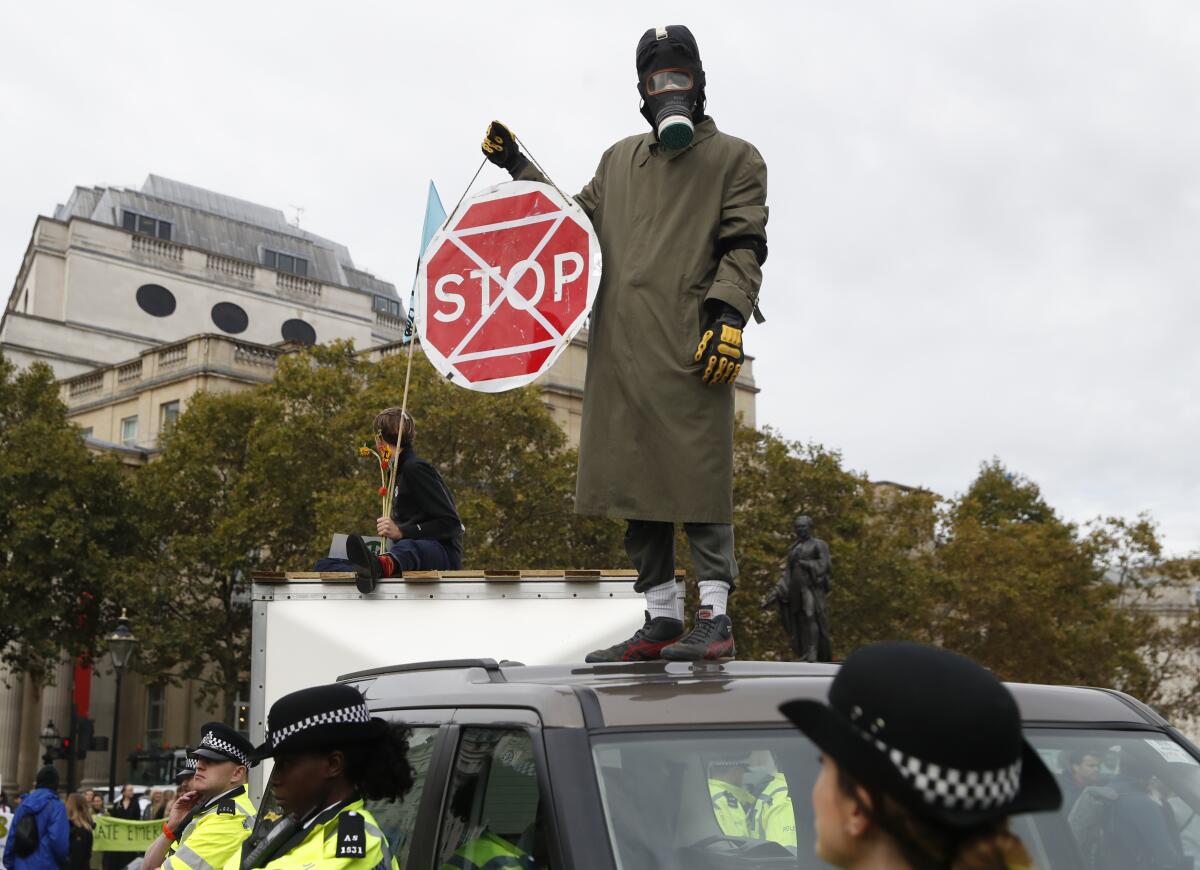 A man in a gas mask is among demonstrators blocking London's Trafalgar Square on Monday.